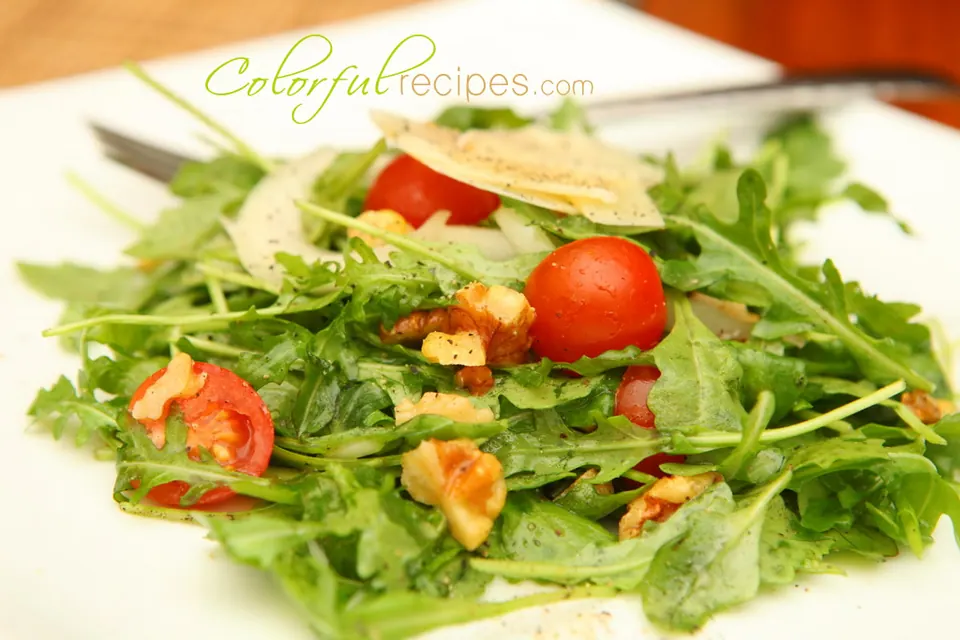 Fresh arugula salad with cherry tomatoes, walnuts and shaved Parmesan