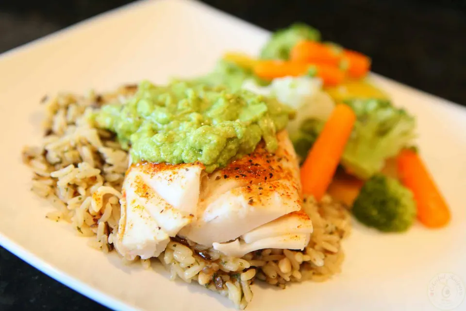 Baked Pacific cod with avocado sauce served over rice with carrots and broccoli