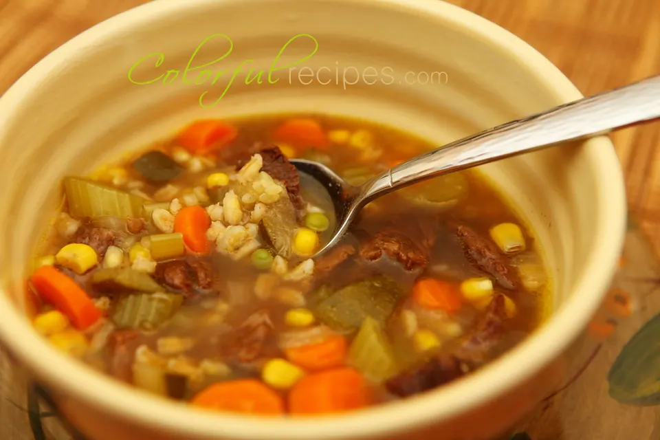 Bowl of vegetable beef barley soup with carrots, corn, celery and tender beef