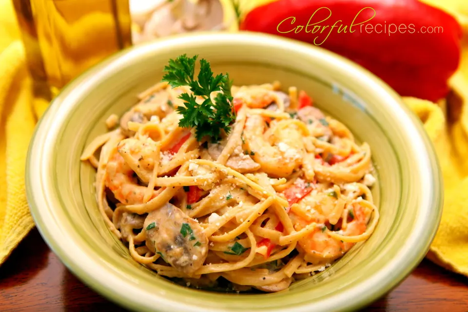 Creamy shrimp linguine in a green bowl garnished with fresh parsley