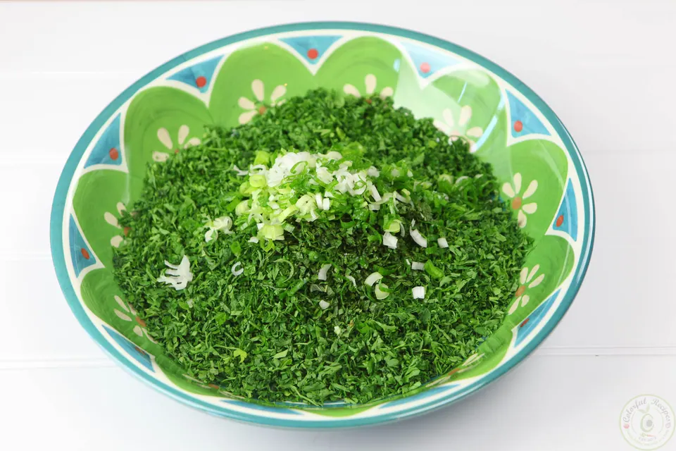 Finely chopped parsley and green onions in a bowl for Lebanese tabbouleh