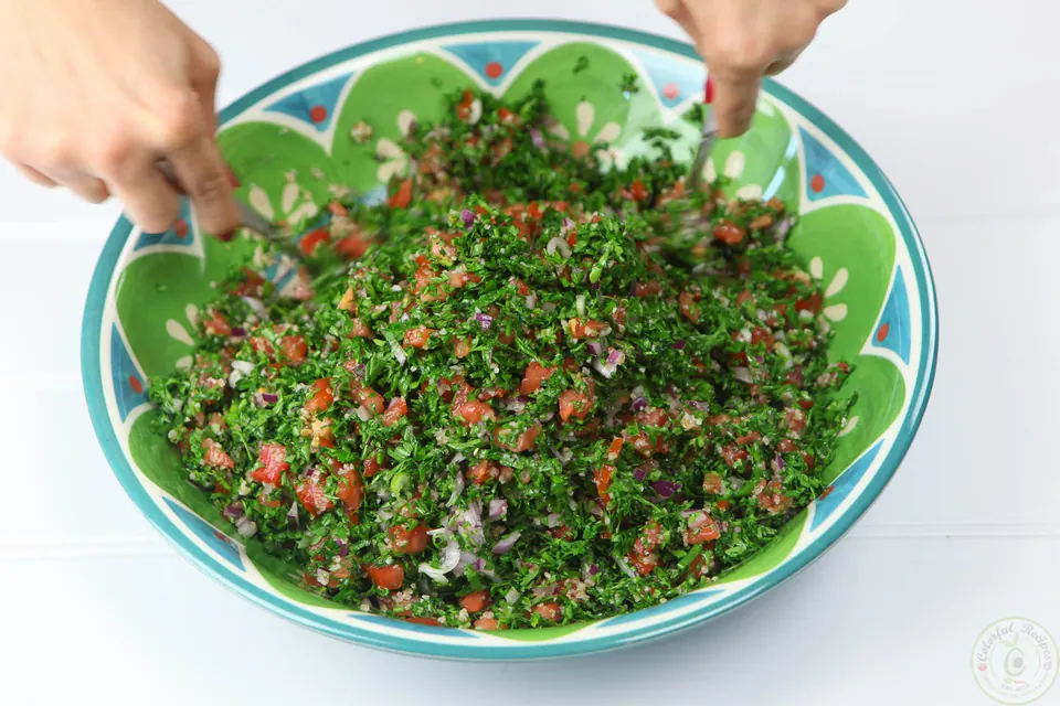 Fully mixed Lebanese tabbouleh in a green bowl
