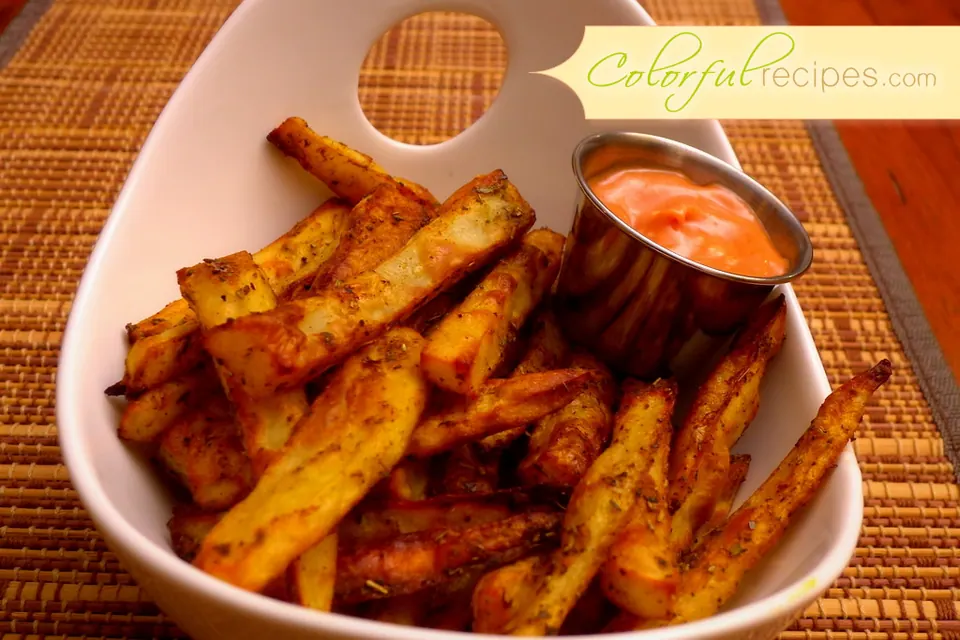 Bowl of crispy healthy baked fries with a side of dipping sauce