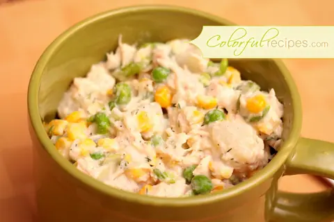 Bowl of tuna potato salad with corn and peas, sprinkled with black pepper