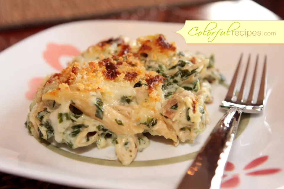 Close-up of creamy spinach chicken penne bake on a plate with a fork