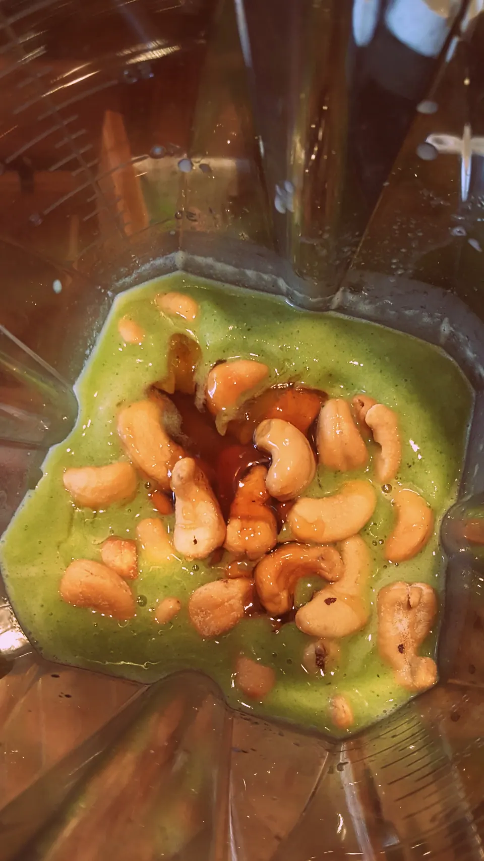 Cashews and honey added to blended kale in a blender for a heart-healthy green smoothie