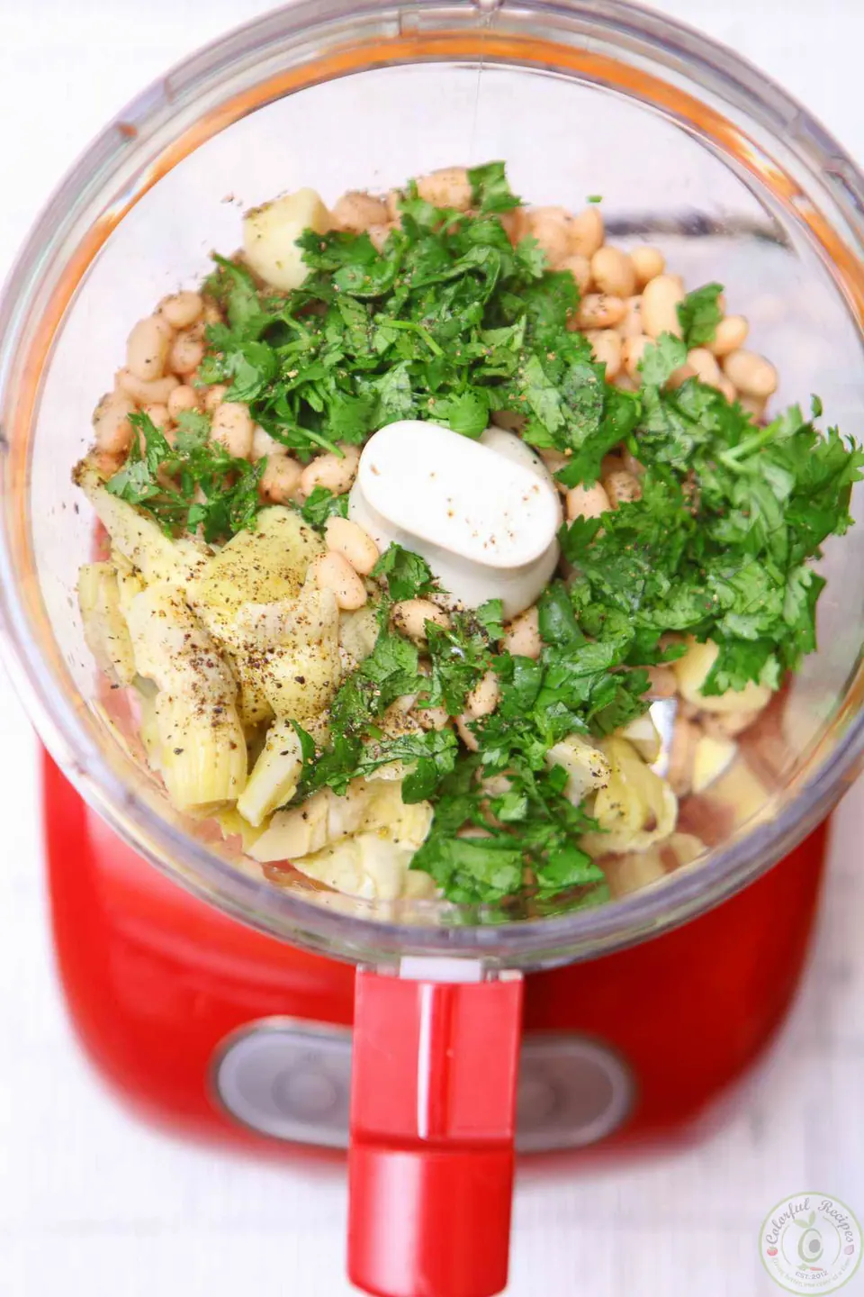 White beans, artichoke hearts and cilantro in a food processor for cilantro white bean artichoke dip