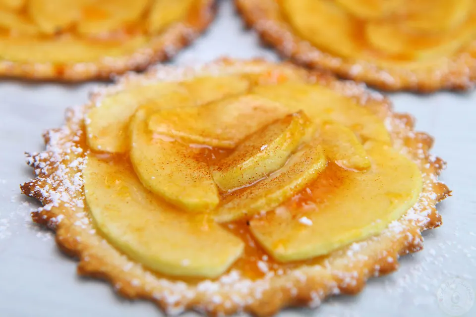 Easiest mini French apple tarts with thin apple slices, apricot glaze and powdered sugar