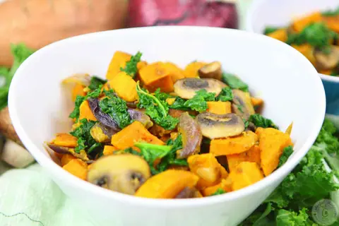 Spiced sweet potato kale mushroom sauté in a white bowl