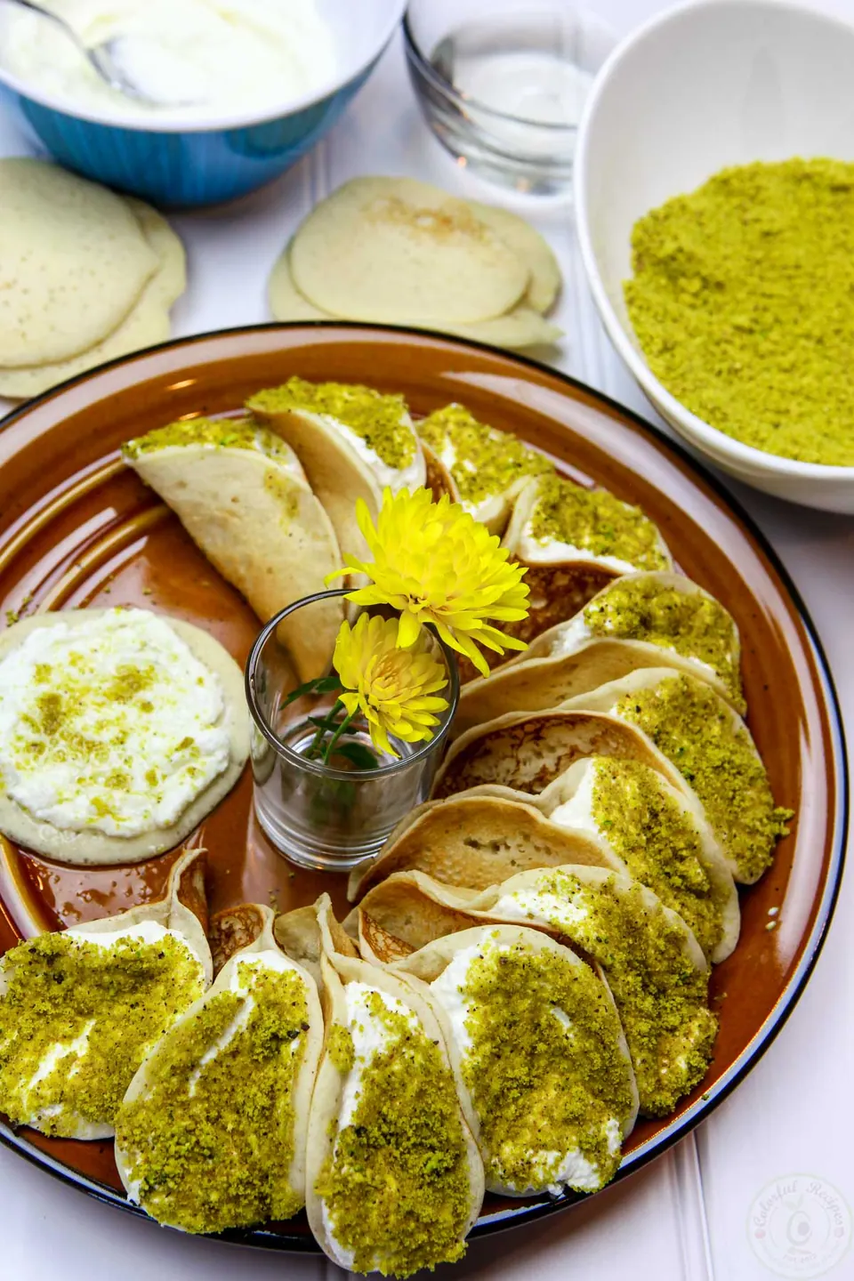 Simple ricotta stuffed atayef dipped in ground pistachios