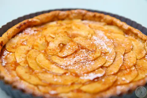 Close-up of a golden easy French apple tart dusted with powdered sugar