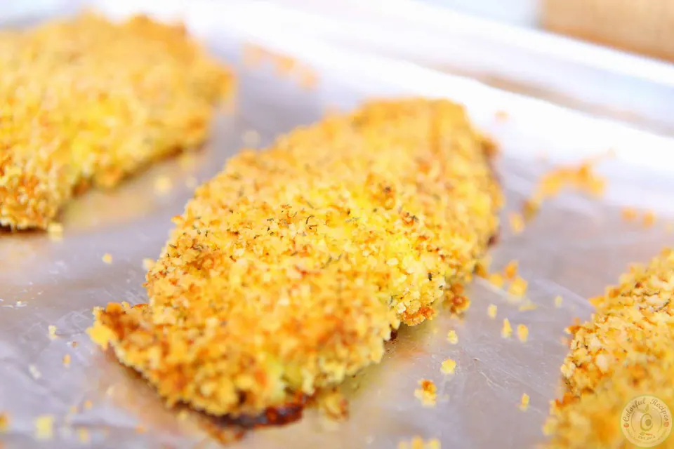 Golden brown Italian oven fried crispy chicken breasts on a baking sheet