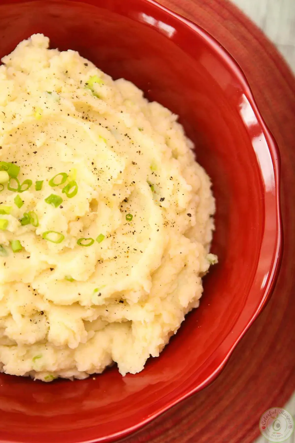 Bowl of creamy roasted garlic parmesan mashed potatoes with green onions