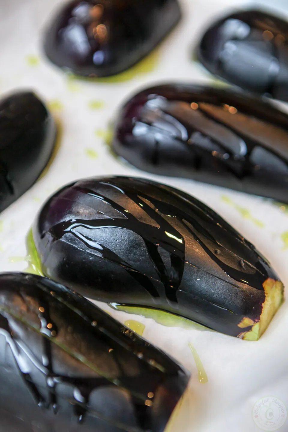 Halved eggplants roasted cut side down on parchment paper for baba ghanouj