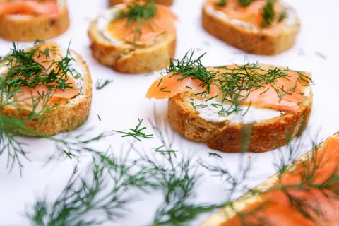 Smoked salmon dill goat cheese baguette bites on parchment paper