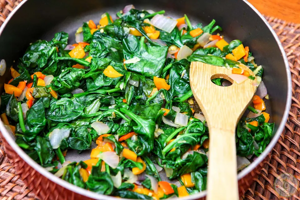 Wilted spinach and vegetables ready for the artichoke spinach dip