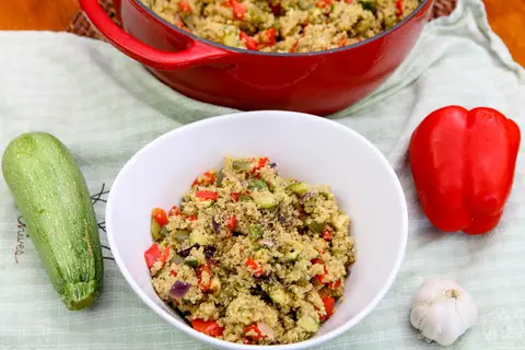 Bowl of roasted veggie quinoa pilaf with red and green peppers and zucchini