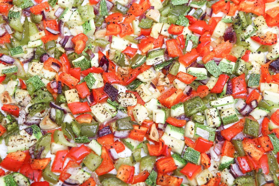 Seasoned diced veggies ready to roast for quinoa pilaf