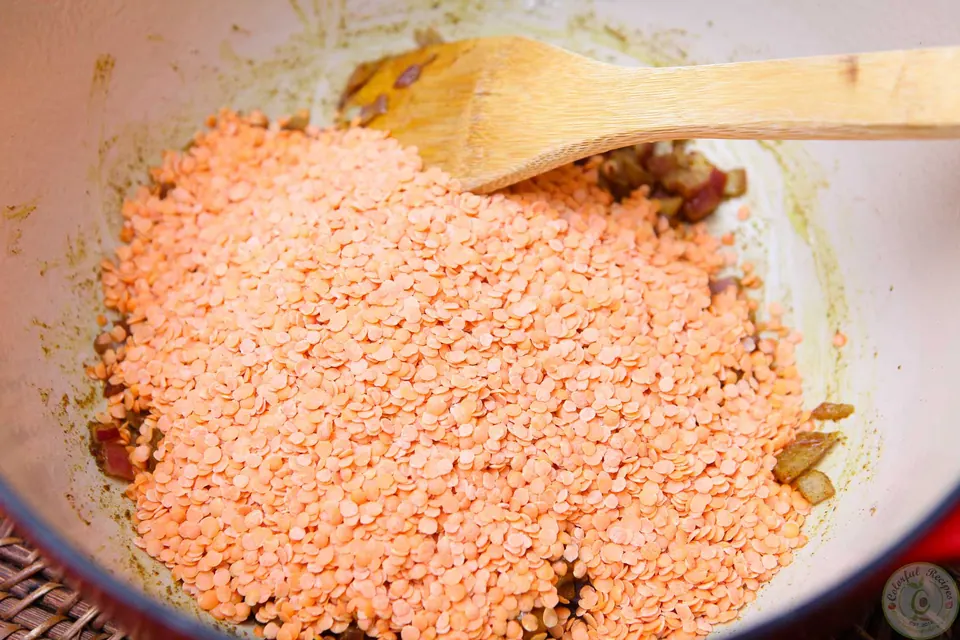 Red lentils added to the sautéed onion and spices