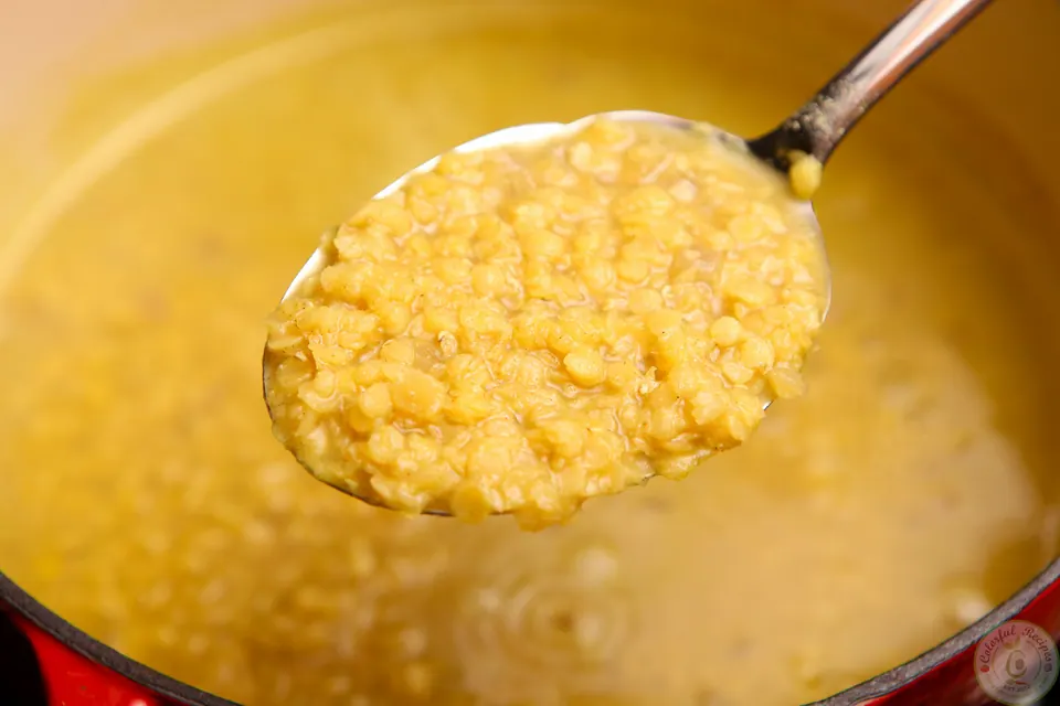 Spoonful of soft cooked red lentils from the pot of Shorbet Adas