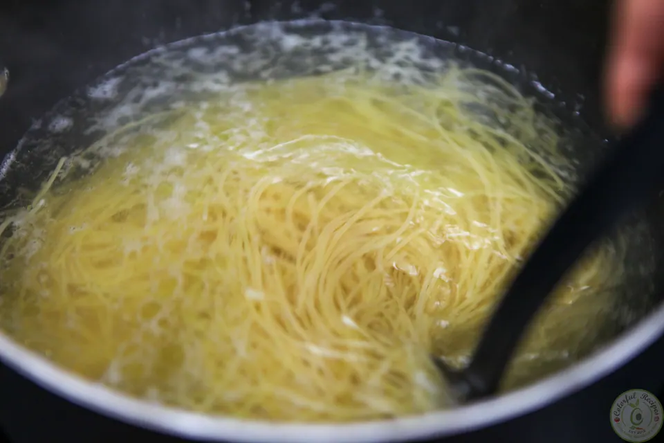 Spaghetti cooking in a pot of boiling water