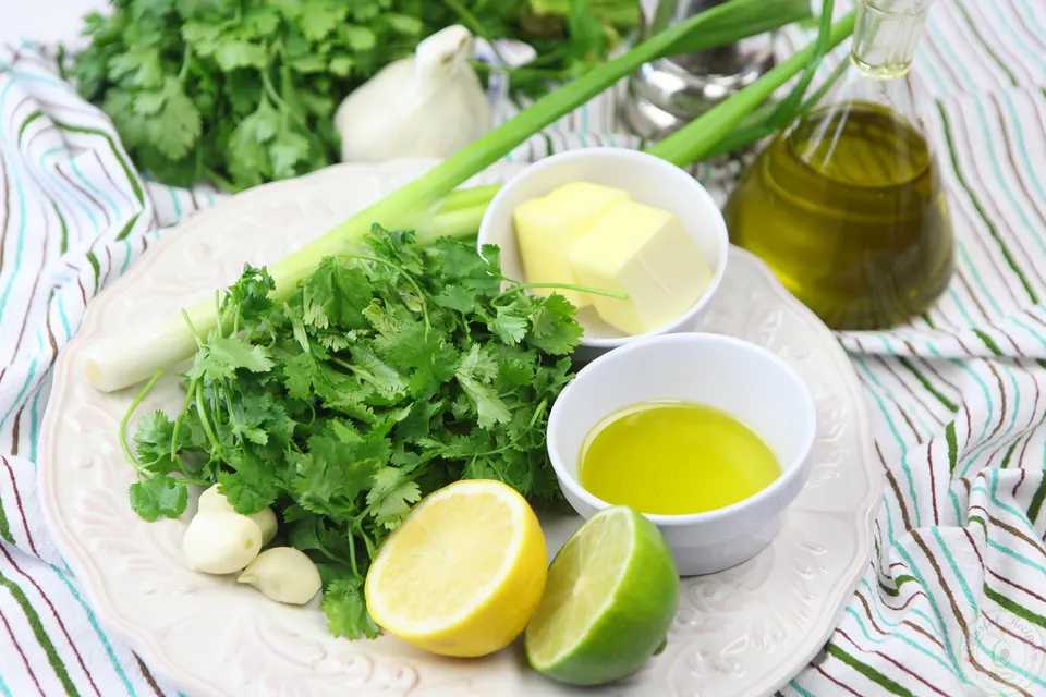 Cilantro, garlic, green onion, butter, lemon, lime and olive oil for cilantro garlic citrus butter