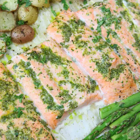 Close-up of one pan salmon topped with cilantro garlic citrus butter, with asparagus and potatoes