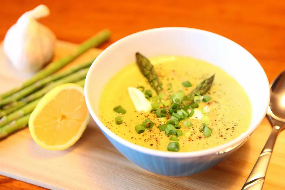 Roasted asparagus creamy soup garnished with green onions and cracked pepper