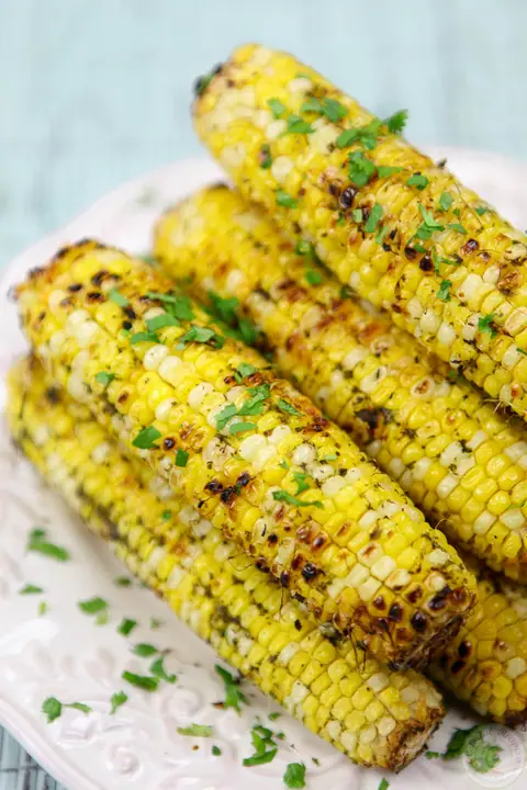 Cilantro garlic citrus butter grilled corn on the cob topped with chopped cilantro