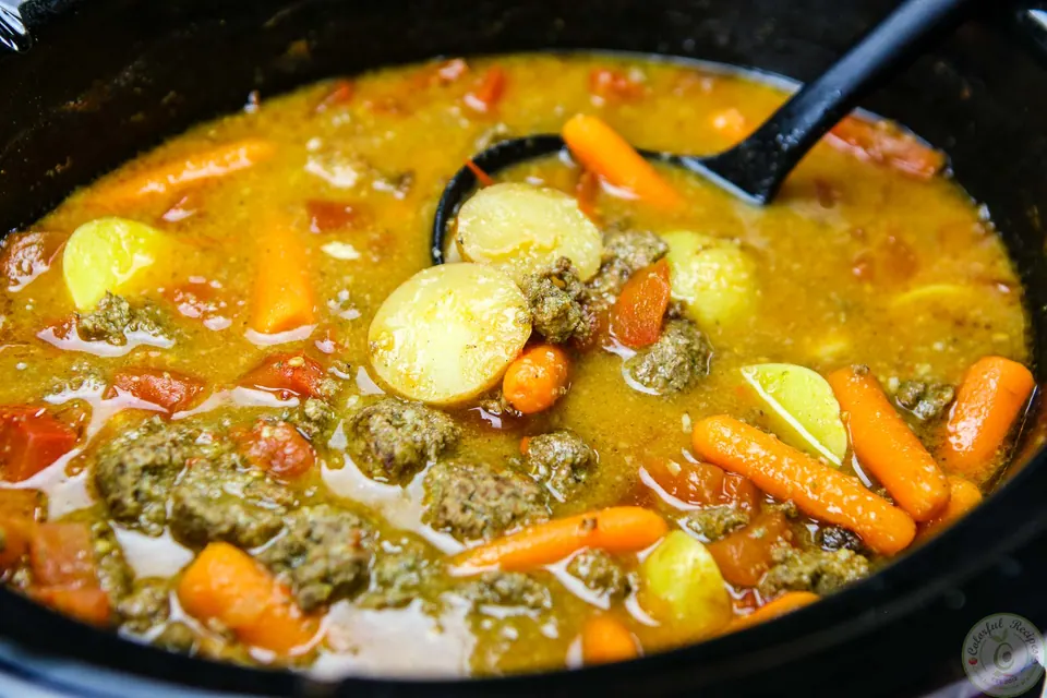 Lebanese kafta meatballs simmering in a slow cooker stew