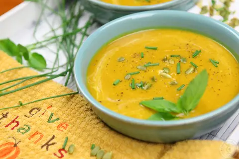 Bowl of creamy butternut squash sweet potato soup garnished with green onions
