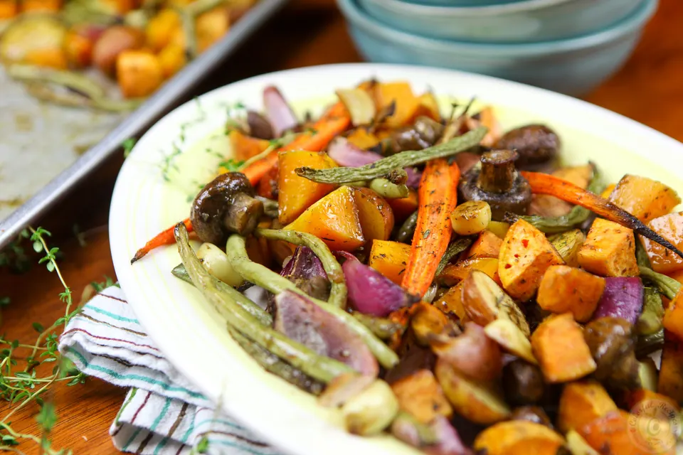 Balsamic roasted fall vegetables with roasted garlic and fresh thyme on a platter