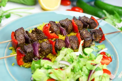 Easy broiled beef kabobs with red pepper and onion on turmeric rice with salad