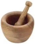 Mortar and pestle used to mince garlic for cabbage tomato salad