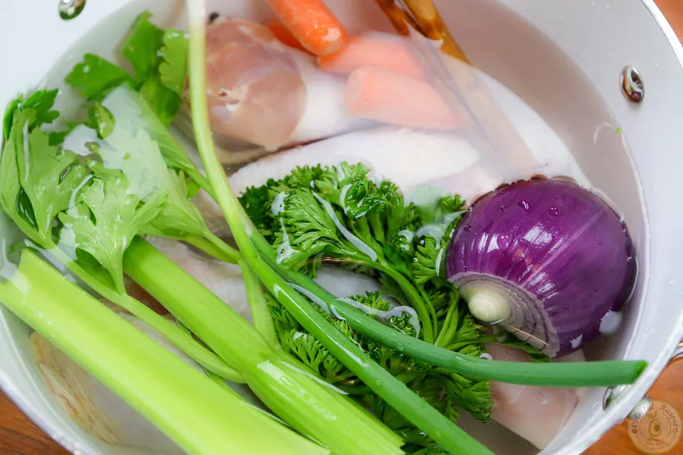 Ladle of homemade alphabet chicken soup with carrots and zucchini