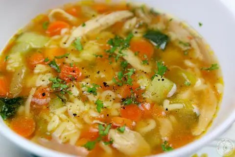 Bowls of toddler approved alphabet chicken soup with carrots, zucchini and alphabet pasta