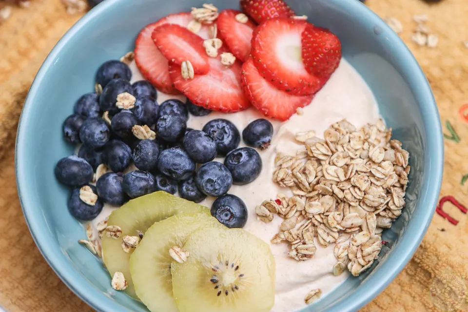 Close-up of a Chinese gooseberry pumpkin breakfast bowl with berries, golden kiwi and granola
