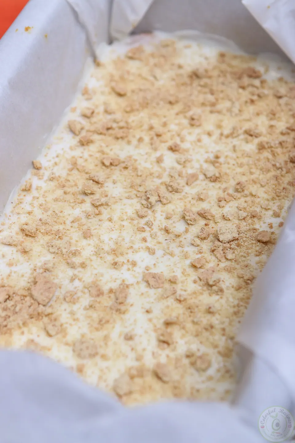 Set pumpkin cheesecake slab lifted out of the pan with parchment