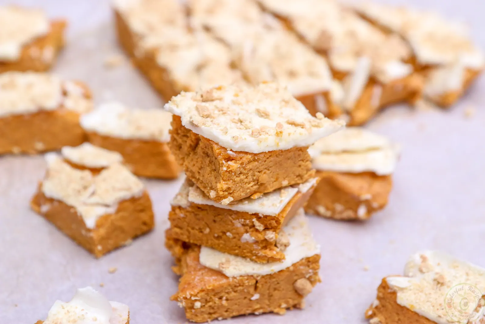 Stack of no bake pumpkin cheesecake bites with white chocolate topping