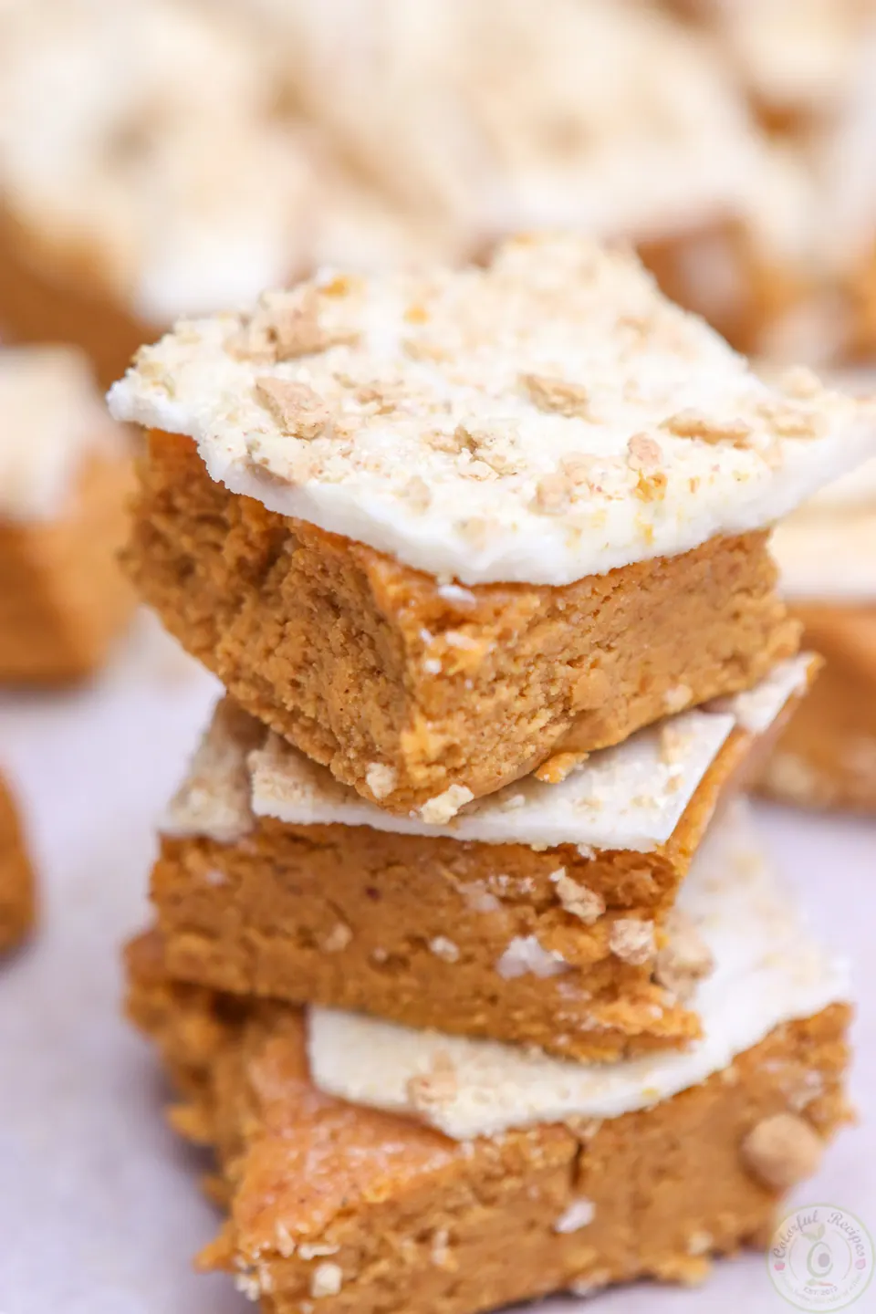 Stack of no bake pumpkin cheesecake bites with white chocolate topping