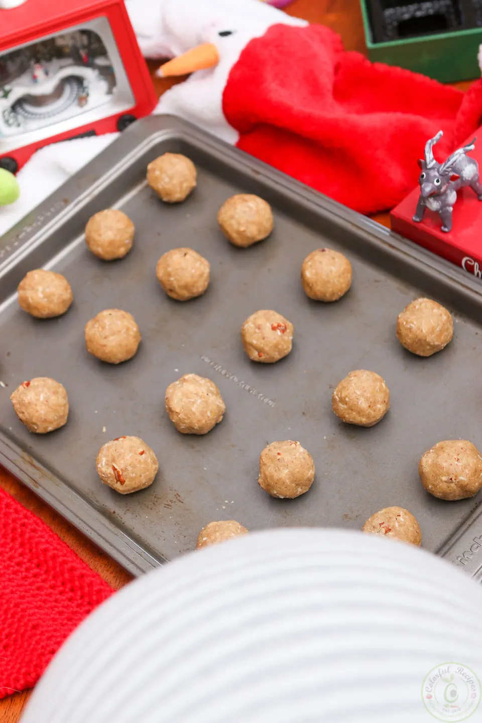 Balls of gluten-free coconut pecan cookie dough on a baking sheet