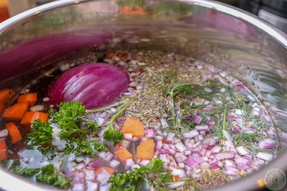 Overhead view of chicken soup ingredients covered with water in the Instant Pot