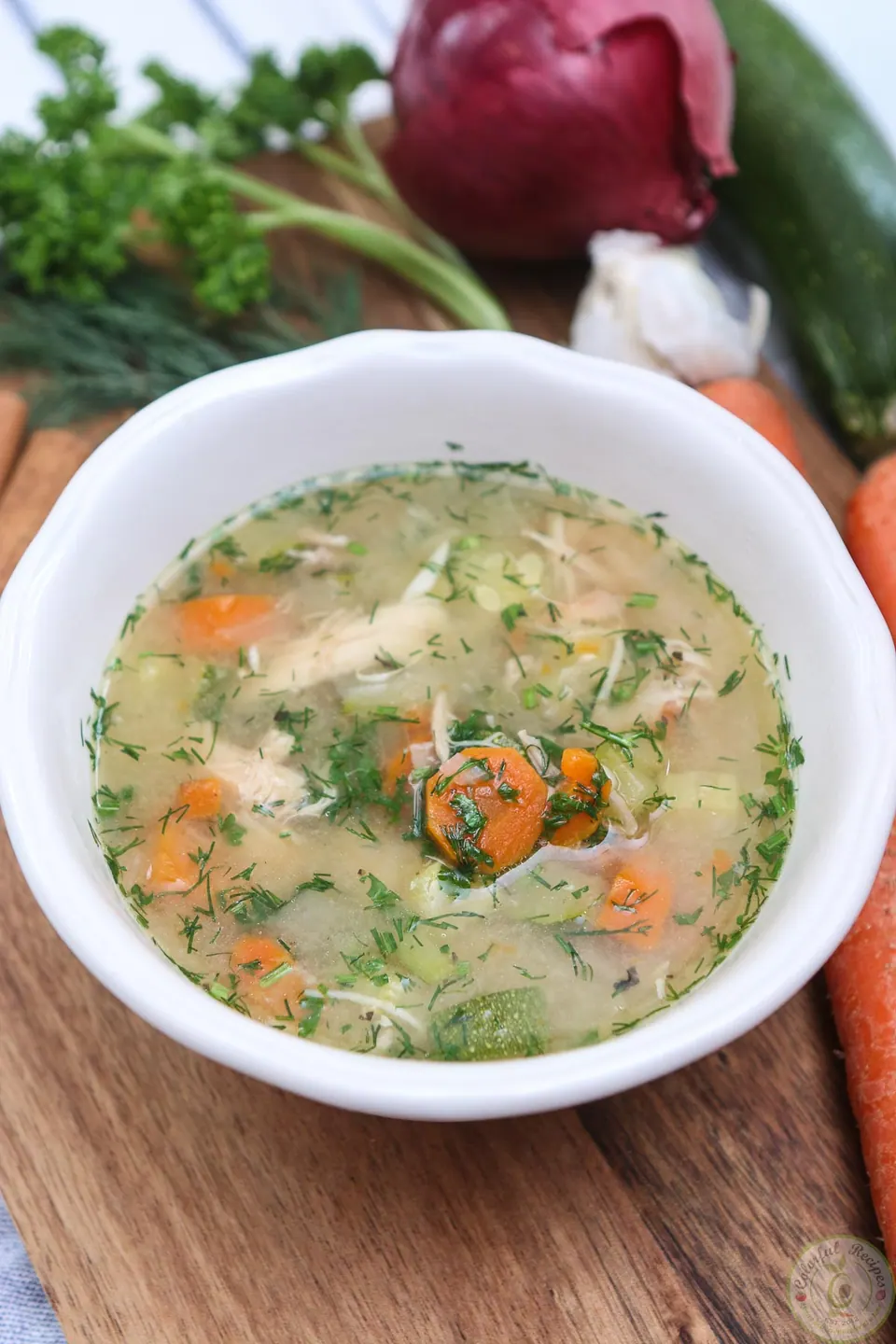 Bowl of Instant Pot chicken soup from scratch with carrots and fresh herbs
