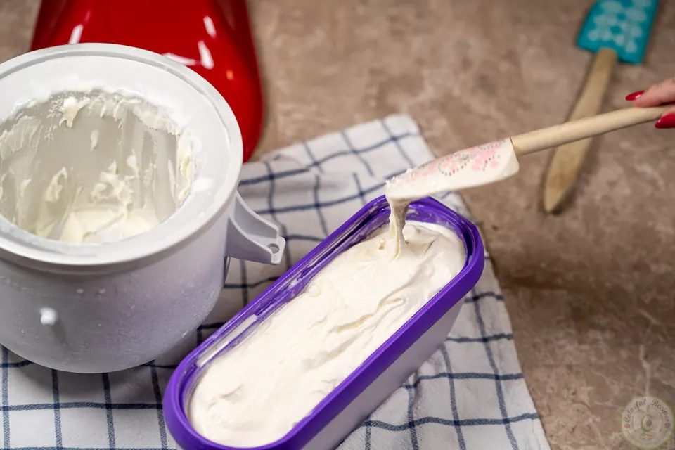 Spreading milk ice cream booza into a container to freeze