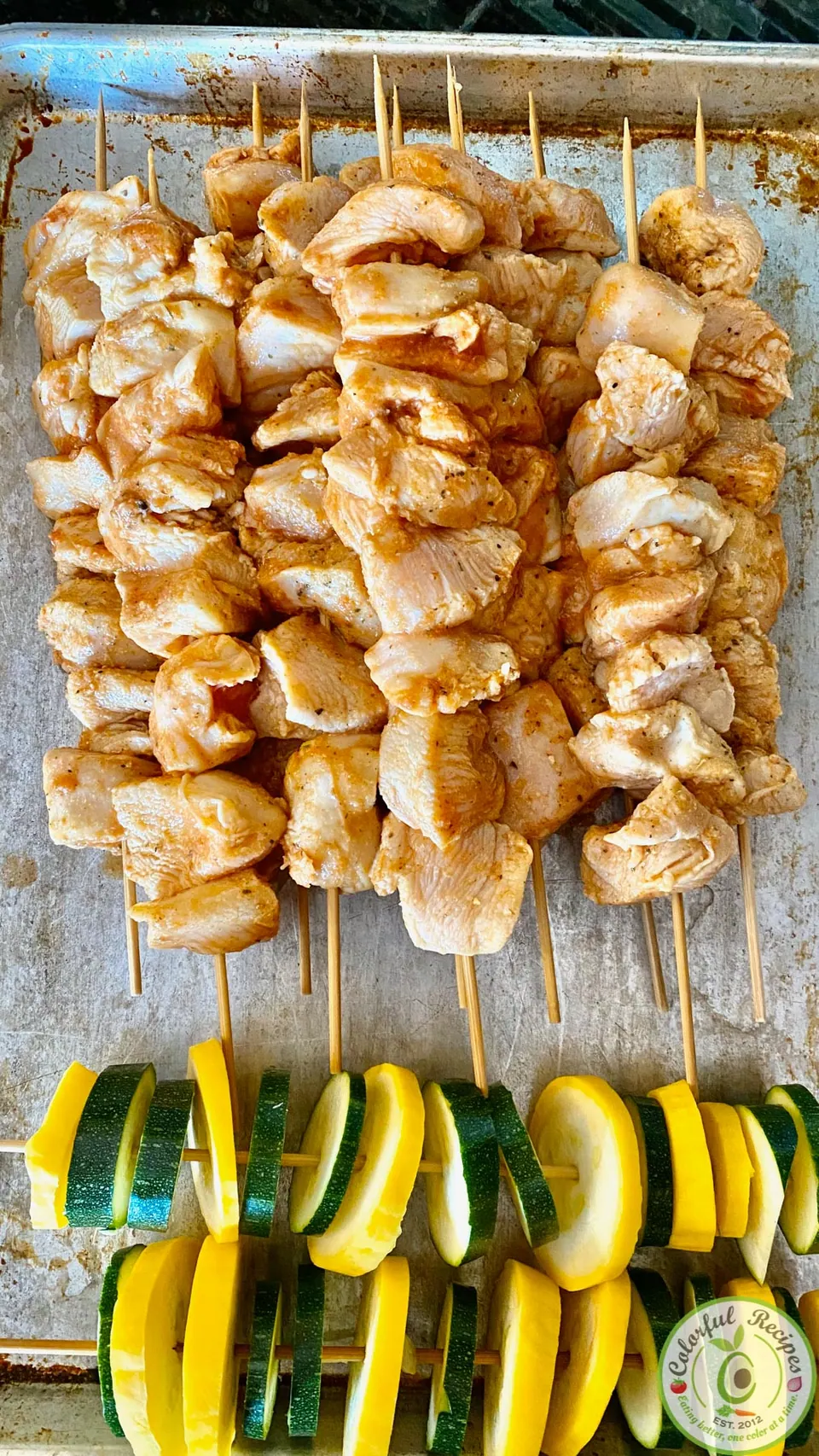 Marinated chicken kabob skewers and sliced zucchini and squash ready for the grill