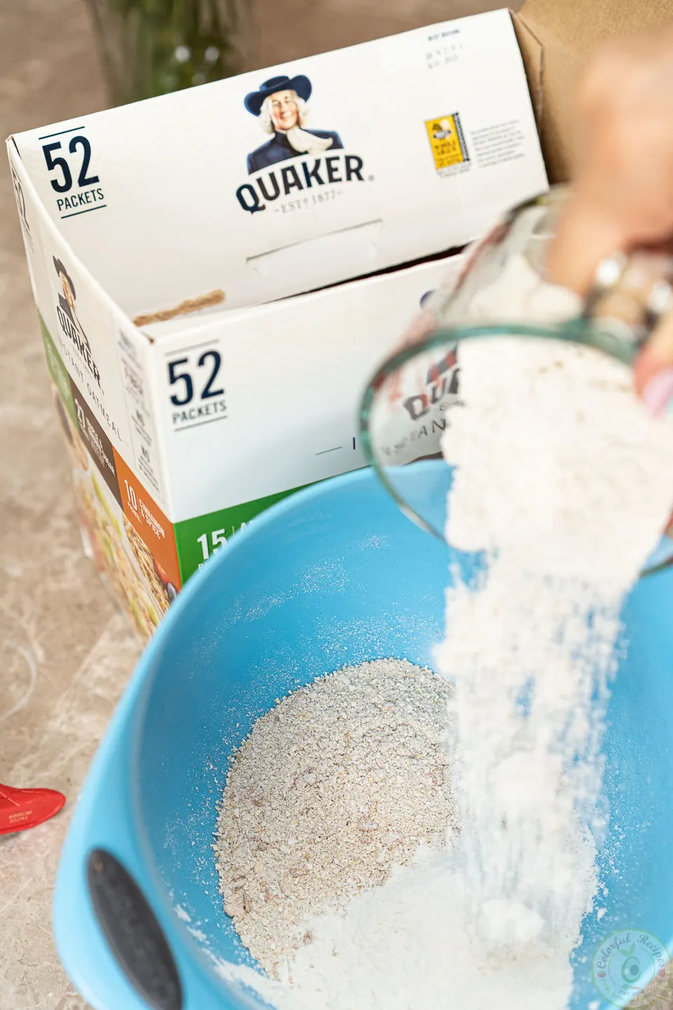Adding flour to ground oats in a mixing bowl for oatmeal pancakes