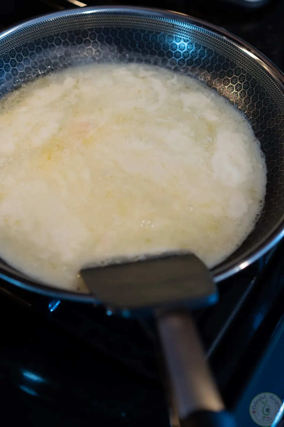 Liquid egg whites starting to set in a nonstick pan