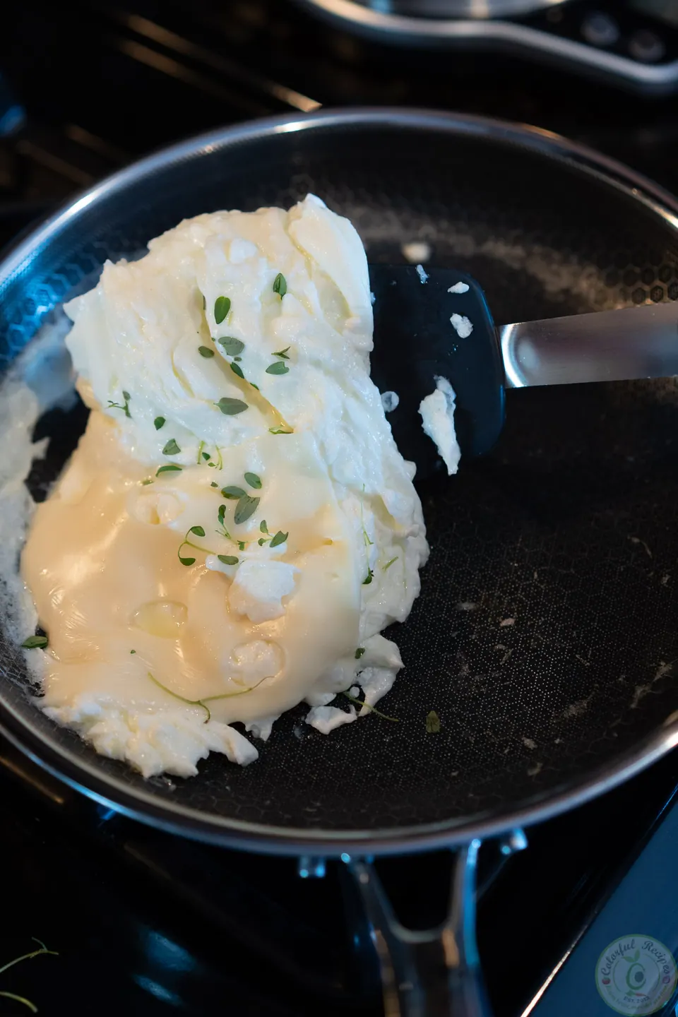 Egg whites with melted cheese and fresh thyme in the pan