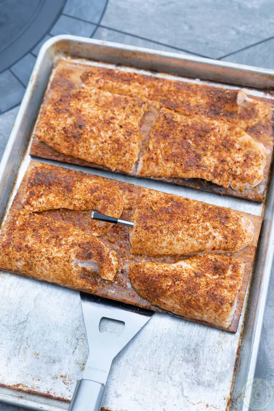 Grilled cedar plank salmon resting in a baking sheet