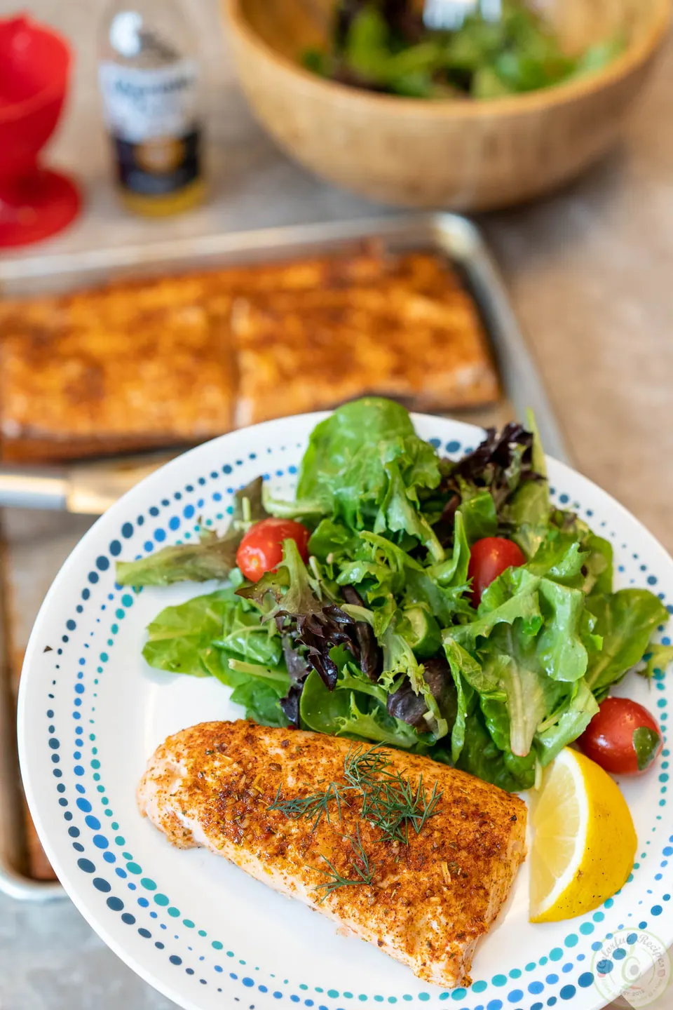 Cedar plank grilled salmon served with a green salad and lemon